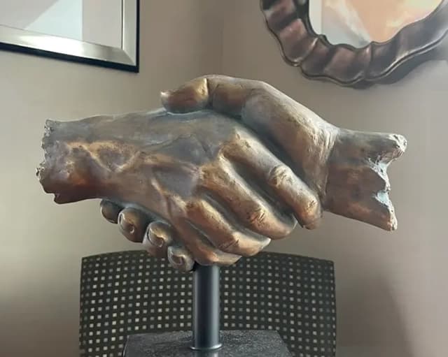 Bronze handshake sculpture inside the Auto Gals, Inc. dealership